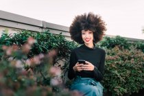 Щаслива молода жінка на відкритому повітрі з мобільним телефоном — стокове фото