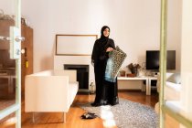 Mujer musulmana joven con alfombra de oración - foto de stock