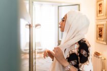 Jovem mulher muçulmana colocando hijab lenço de cabeça — Fotografia de Stock