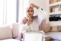 Молодая мусульманка надевает хиджабский платок — стоковое фото
