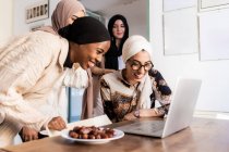 Young muslim women on video call, with plate of dates — Stock Photo