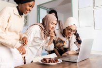 Young muslim women on video call, with plate of dates — Stock Photo