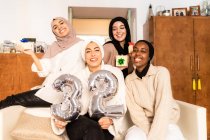 Portrait of friends with gifts and number 32 balloons — Stock Photo