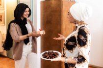 Giovani donne musulmane con dono e date — Foto stock