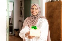 Jovem mulher muçulmana dando um presente — Fotografia de Stock