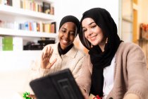 Deux jeunes femmes musulmanes utilisant une tablette pour un appel — Photo de stock