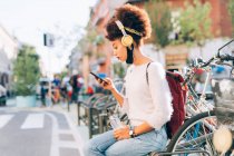 Junge Frau im Freien und schaut aufs Handy — Stockfoto