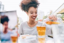 Jovem mulher derramando bebida no café ao ar livre — Fotografia de Stock