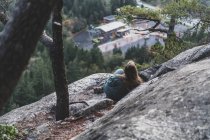 Kanada, British Columbia, Squamish, Junge Frau sitzt auf einem Felsen — Stockfoto