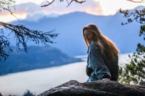 Canada, British Columbia, Squamish, Young woman sitting on rock — Stock Photo