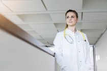 Германия, Бавария, Мюнхен, Молодая женщина-врач, стоящая в коридоре — стоковое фото
