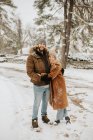 Канада, Онтарио, обнимающая пара, стоящая на снежной дороге — стоковое фото