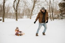 Kanada, Ontario, Vater zieht Tochter (2-3) auf Rodel — Stockfoto