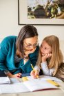 Reino Unido, Surrey, Mãe assistente filha (10-11) fazendo lição de casa em casa — Fotografia de Stock