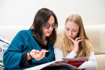 UK, Surrey, Mutter hilft Tochter (10-11) bei Hausaufgaben zu Hause — Stockfoto
