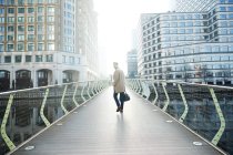 Великобритания, Лондон, Человек ходит по пешеходному мосту — стоковое фото