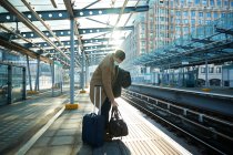 UK, London, Man waiting at train station platform — Stock Photo