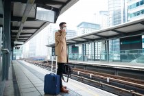UK, London, Man waiting at train station platform — Stock Photo