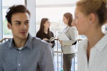 Germany, Bavaria, Munich, Male and female students talking in corridor — Stock Photo