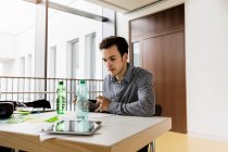 Germany, Bavaria, Munich, Young man working at desk — Stock Photo