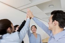Germany, Bavaria, Munich, Business people doing high-five together in office — Stock Photo
