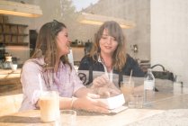Дві жінки п'ють каву в кафе — стокове фото