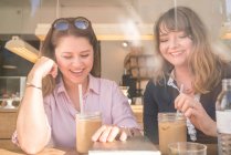Дві жінки п'ють каву в кафе — стокове фото