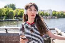 Germany, Berlin, Young woman wearing headphones — Stock Photo