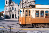 Portugal, Porto, Altmodische Straßenbahn fährt an Igreja do Carmo vorbei — Stockfoto