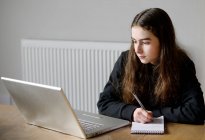 Young girl using laptop at home — Stock Photo