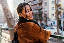 Italia, Retrato de una joven sonriente en la ciudad - foto de stock