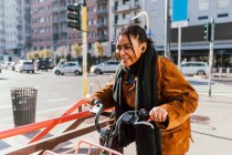 Italien, Lächelnde junge Frau mit Fahrrad auf der Straße der Stadt — Stockfoto