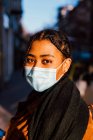 Itália, Retrato de jovem mulher na máscara de pé na rua da cidade — Fotografia de Stock