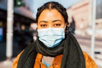 Italia, Retrato de mujer joven con máscara facial de pie en la calle de la ciudad - foto de stock