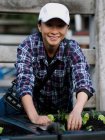 Australien, Melbourne, Lächelnde Frau pflanzt Setzlinge im Gemeinschaftsgarten — Stockfoto