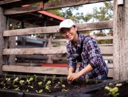 Australia, Melbourne, Donna sorridente piantare piantine in giardino comunitario — Foto stock