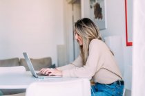 Italien, Junge Frau benutzt Laptop zu Hause — Stockfoto