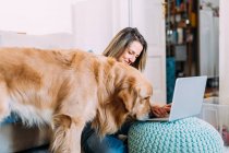 Italy, Young woman with dog at home — Stock Photo