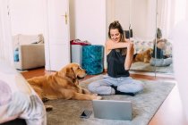 Italy, Young woman and dog at home — Stock Photo