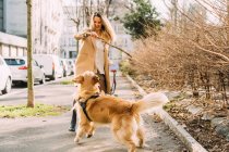 Italy, Young woman playing with dog on trowalk — стоковое фото