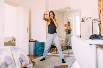 Италия, Молодая женщина тренируется дома — стоковое фото
