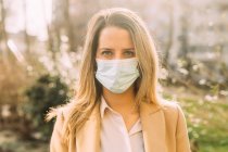 Italy, Portrait of young woman wearing protective face mask — Stock Photo