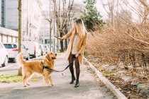 Italien, Frau mit Hund geht Straße entlang — Stockfoto