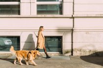 Itália, Mulher com cão andando ao longo da rua — Fotografia de Stock