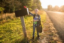 Канада, Онтаріо Хлопчик стоїть біля поштової скриньки на узбіччі сонця. — стокове фото