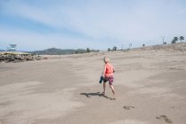 USA, California, Ventura, Rear view of boy running on beach — Stock Photo