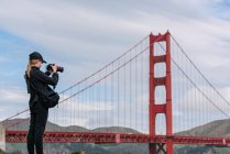 США, Калифорния, Сан-Франциско, Девушка фотографирует мост Golden Gate — стоковое фото