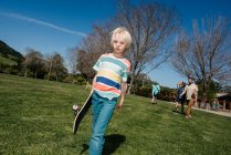 USA, California, Big Sur, Boy with skateboard walking in park — Stock Photo