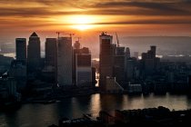Reino Unido, Londres, arranha-céus Canary Wharf e rio Tâmisa ao pôr do sol — Fotografia de Stock