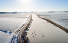 Nederland, Friesland, Broek, Aerial view of frozen canal and snow covered fields — Stock Photo